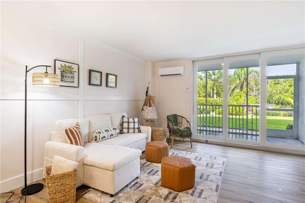5 Bluebill Avenue, Unit 105 Naples, FL 34108 - Photo 19 of 26 a living room with furniture and a large window