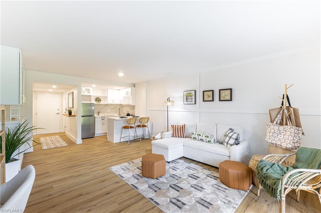 5 Bluebill Avenue, Unit 105 Naples, FL 34108 - Photo 21 of 26 a living room with furniture and wooden floor