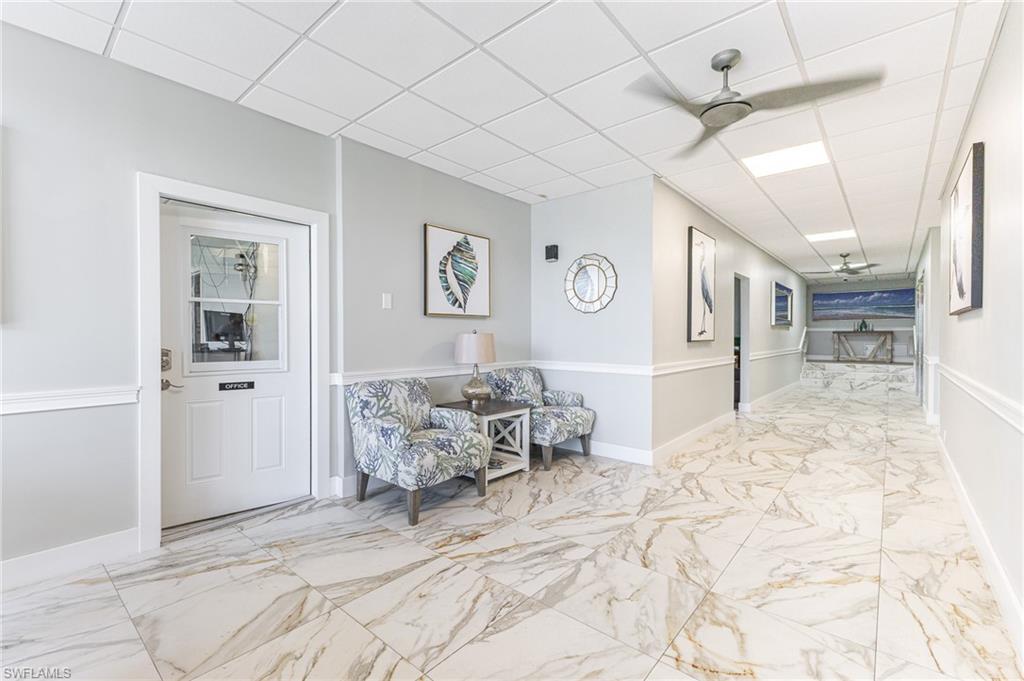 5 Bluebill Avenue, Unit 105 Naples, FL 34108 - Photo 10 of 26 a bedroom with furniture and a large mirror