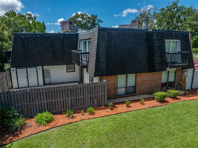 a view of a house with a small yard and wooden fence