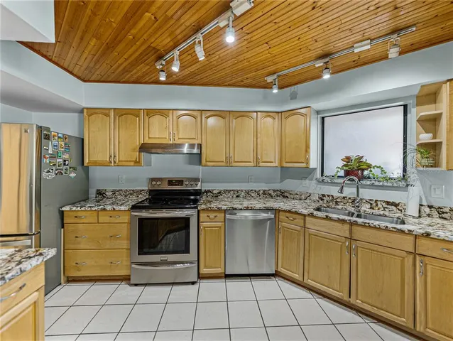 a view of a hallway with wooden floor and a bathroom