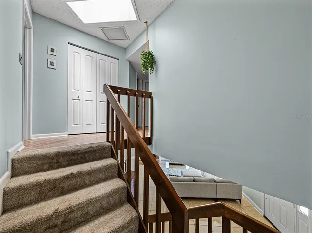 a view of a hallway with wooden floor and staircase