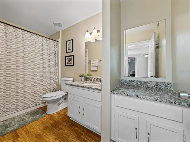 a view of a livingroom with wooden floor and furniture