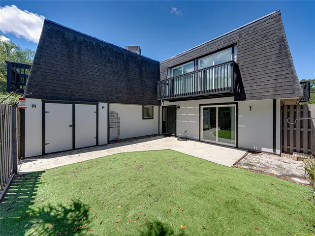 an aerial view of residential houses with outdoor space and trees