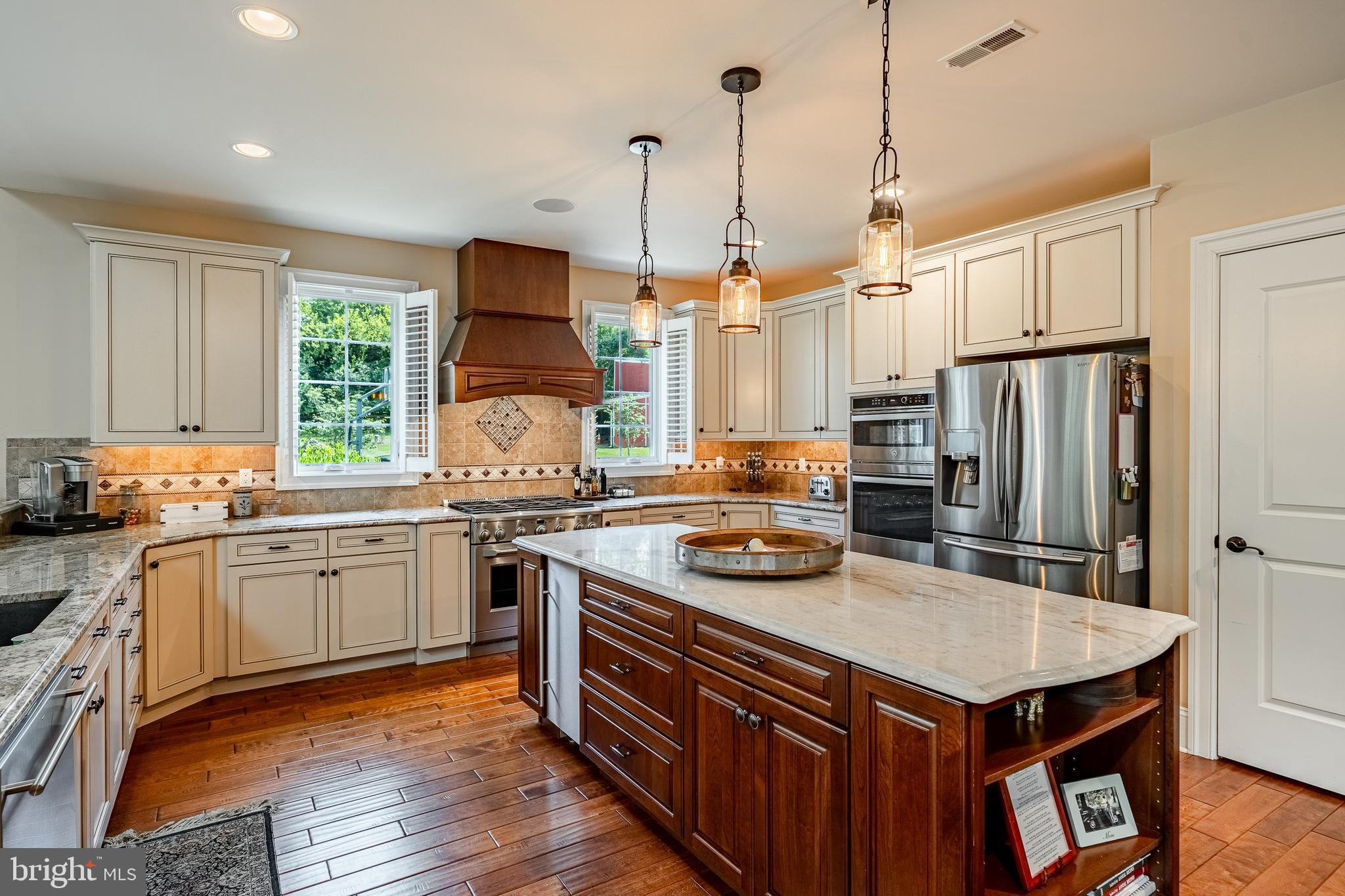 211 Dutton Mill Road West Chester, PA 19380 - Photo 14 of 71 a kitchen with stainless steel appliances granite countertop a stove a sink dishwasher a refrigerator and a dining table with wooden floor