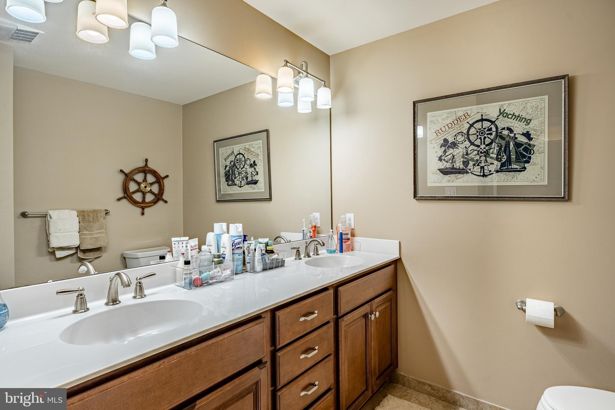 211 Dutton Mill Road West Chester, PA 19380 - Photo 32 of 71 a bathroom with double vanity sinks a toilet a mirror and shower
