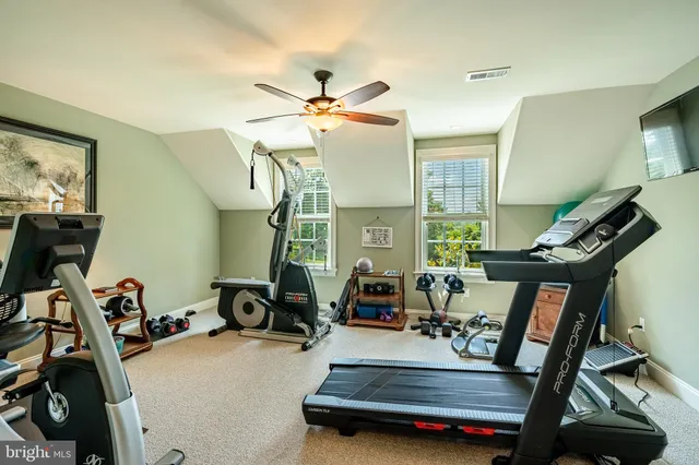 a living room with furniture a ceiling fan and a large window