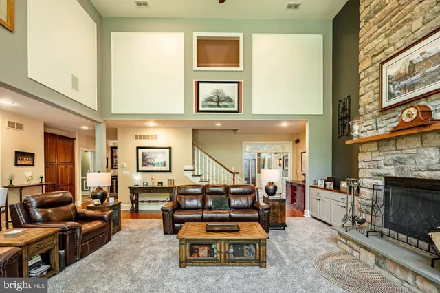 a kitchen with stainless steel appliances granite countertop a stove a sink dishwasher a refrigerator and a dining table with wooden floor