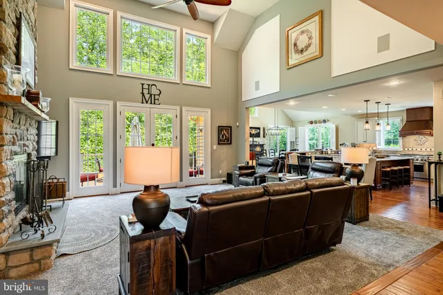 a kitchen with stainless steel appliances granite countertop a stove a sink a microwave a dining table and chairs with wooden floor