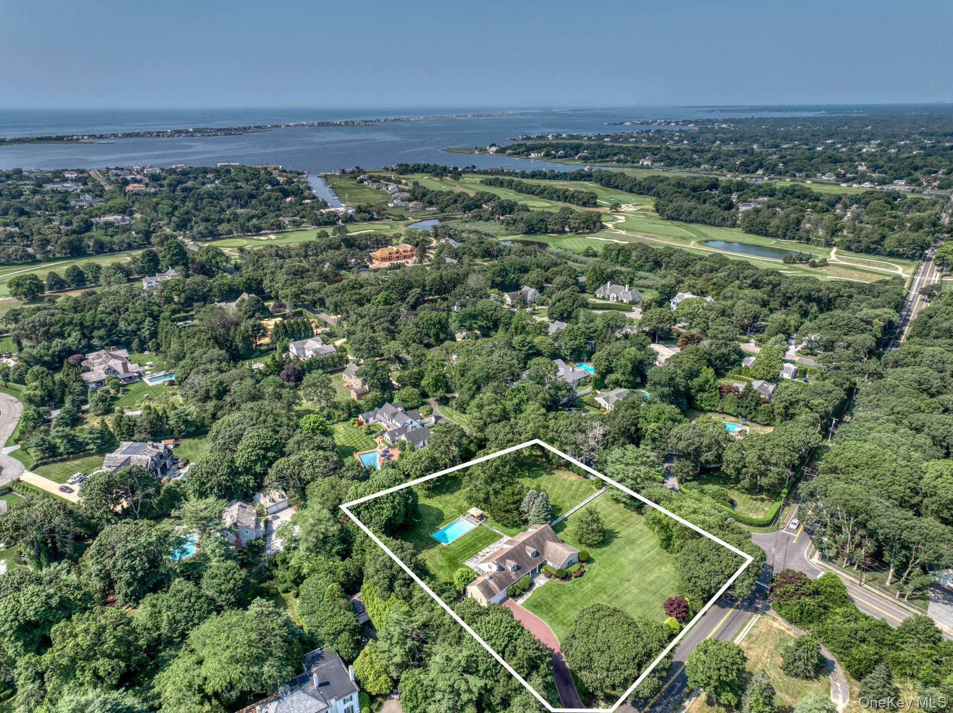 Aerial view of property's location featuring a large body of water, property parcel outlined, and a tree filled landscape