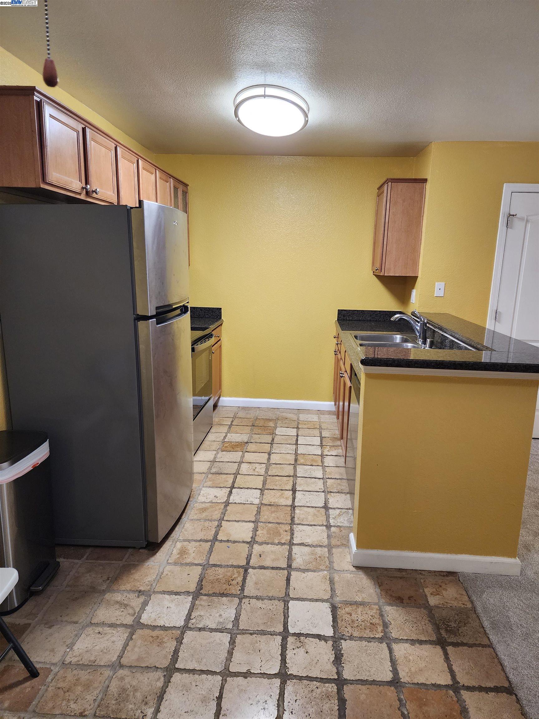 484 Dempsey Road, Unit 186 Milpitas, CA 95035 - Photo 8 of 25 a view of a refrigerator in kitchen and an empty room