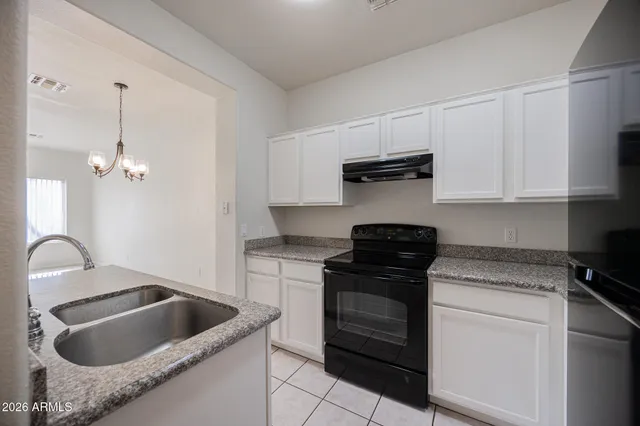 a kitchen with granite countertop a stove and a sink
