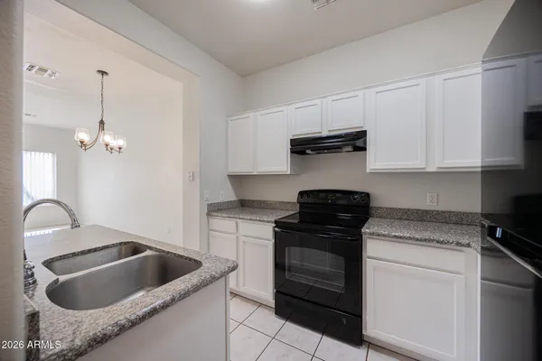 a kitchen with granite countertop a sink and a stove