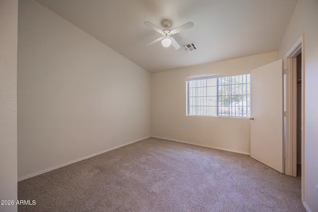 an empty room with windows and fan
