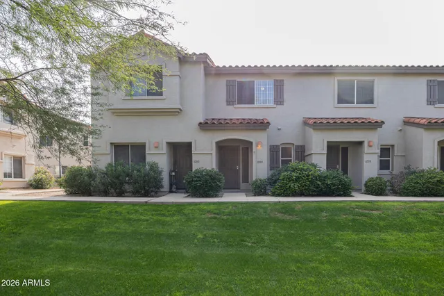 a front view of a house with a garden and yard