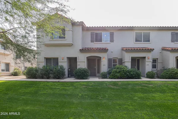 a front view of a house with a garden and yard