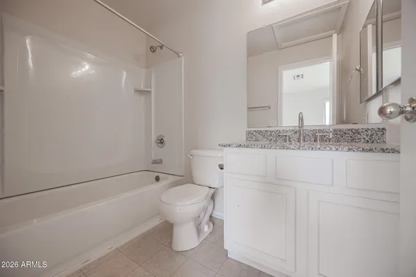 a bathroom with a granite countertop sink a toilet and shower