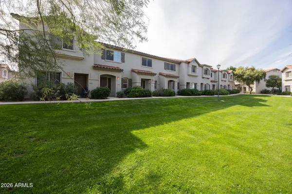 a view of a big building with a big yard and large trees