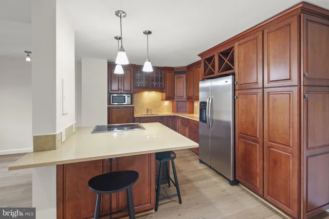 a kitchen with stainless steel appliances granite countertop a refrigerator a sink and a stove