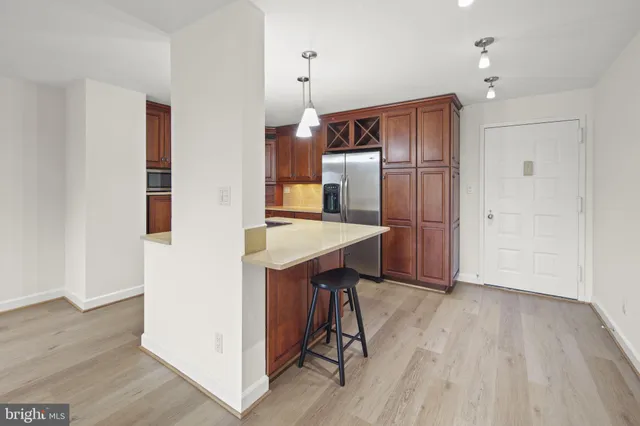 a kitchen with stainless steel appliances granite countertop a refrigerator a sink and a stove