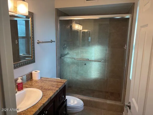 a bathroom with a granite countertop sink toilet and shower