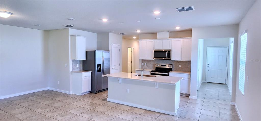 3538 Treetop Street DeLand, FL 32724 - Photo 3 of 7 a kitchen with refrigerator and microwave