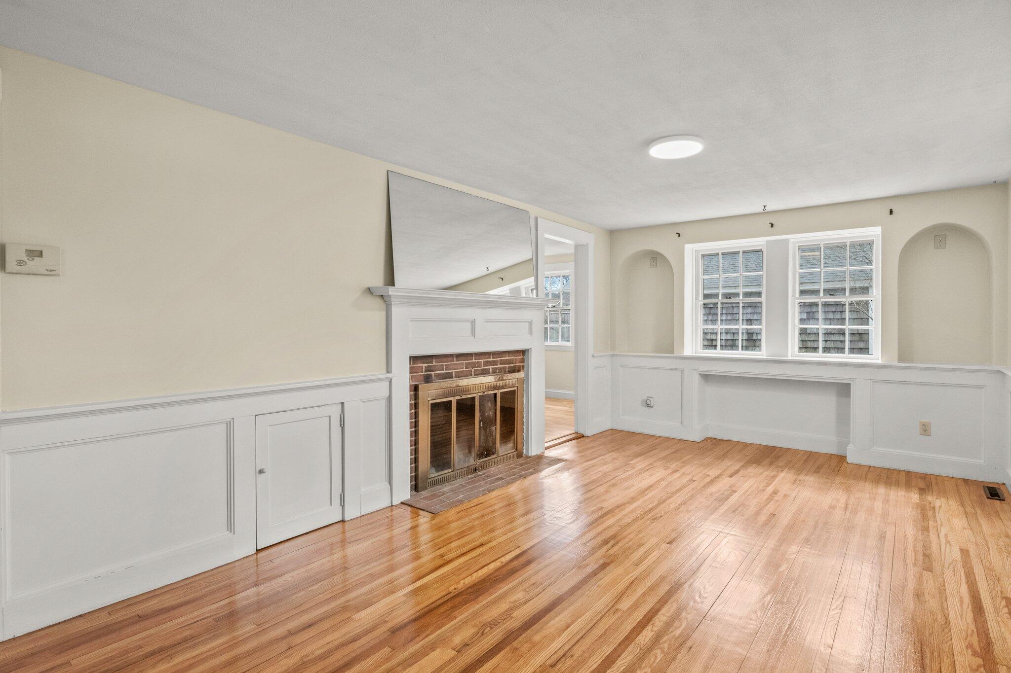 16 Oak Street Hyannis, MA 02601 - Photo 6 of 38 a view of empty room with wooden floor and fireplace