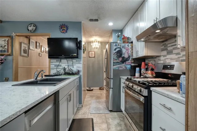 a kitchen with stainless steel appliances granite countertop a sink stove and refrigerator
