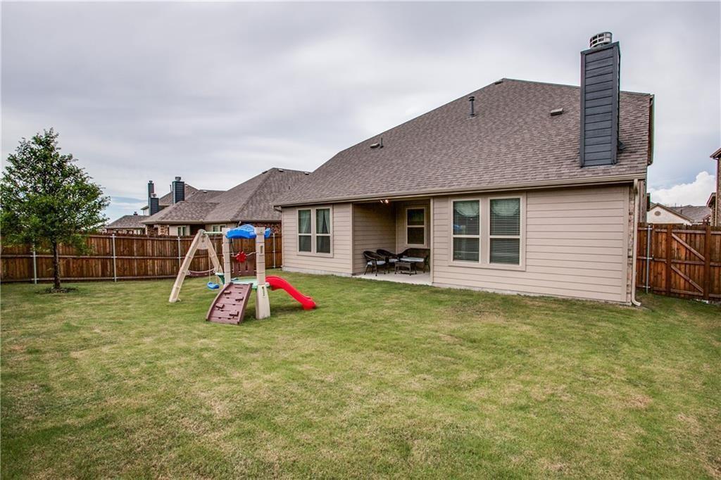 300 Rugby Lane McKinney, TX 75072 - Photo 21 of 25 Expansive backyard with a manicured lawn, a full wood privacy fence, and a covered patio area