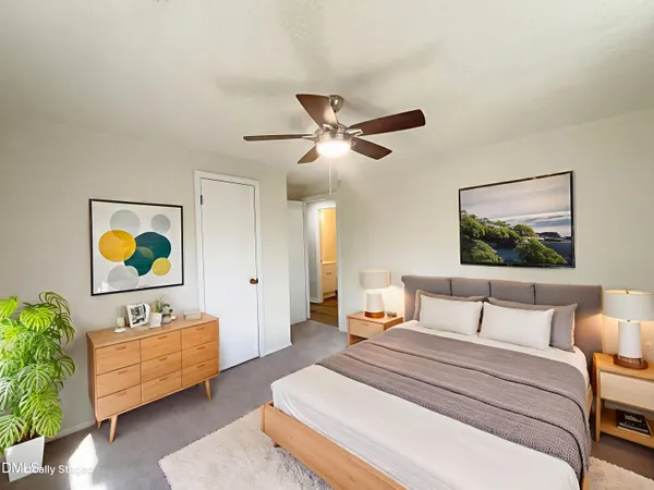 a bedroom with a bed and painting on the wall