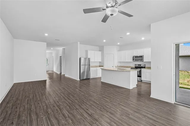 a view of kitchen with refrigerator microwave and stove with wooden floor