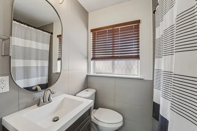 a bathroom with a sink a toilet and mirror