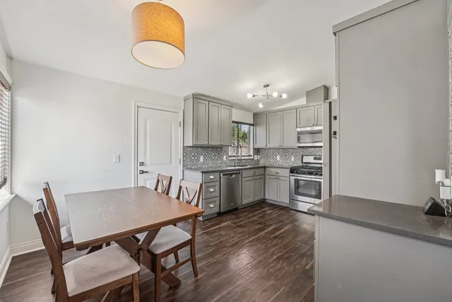 a kitchen with white cabinets and wooden floor