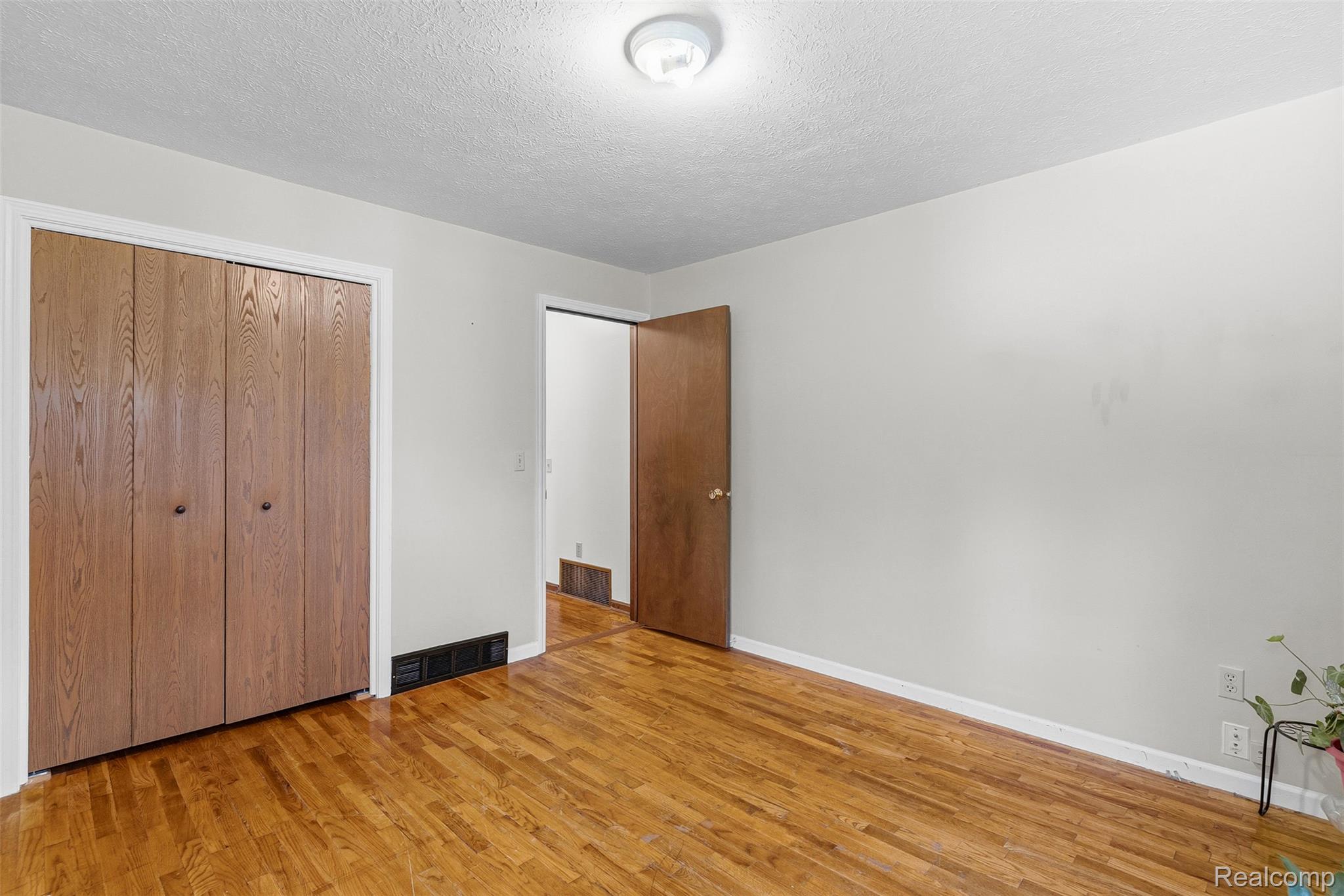 6699 Lansing Road Durand, MI 48429 - Photo 23 of 53 Interior space featuring wood-finish flooring, light neutral wall paint, and a textured ceiling