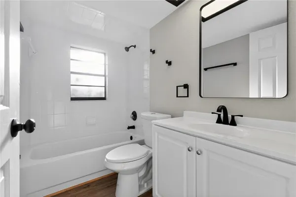 a bedroom with a bed and a potted plant with wooden floor
