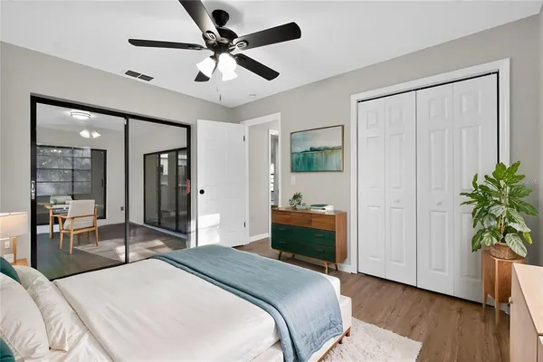 a view of a livingroom with wooden floor and a ceiling fan