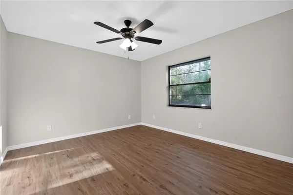 a view of empty room with wooden floor