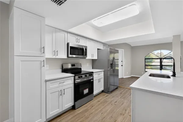 a spacious bathroom with a granite countertop sink a mirror and a bathtub