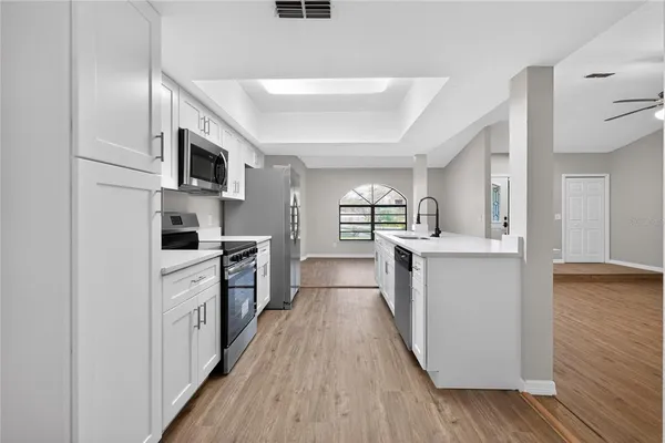 a view of an empty room with window and wooden floor