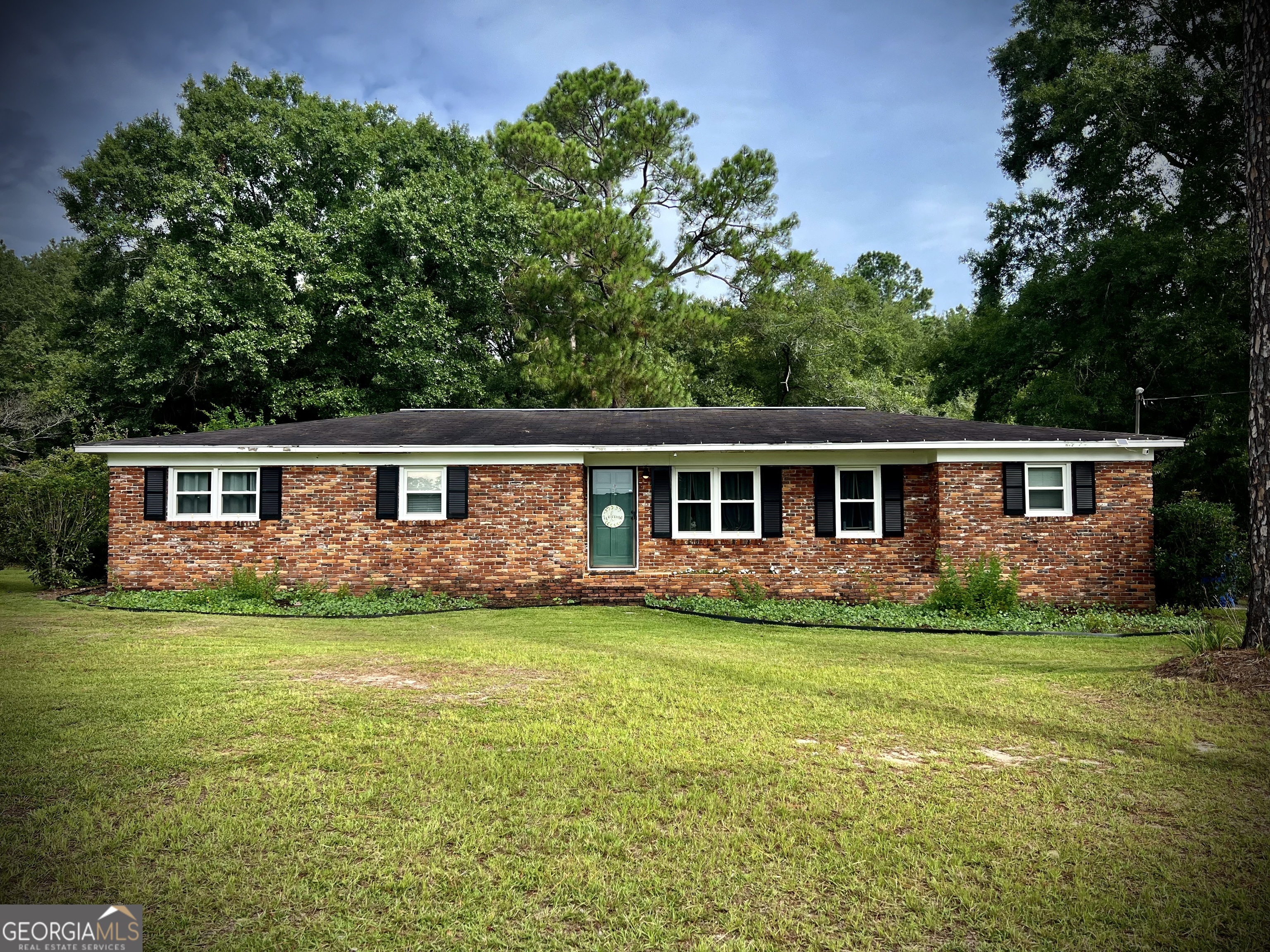 a front view of a house with a garden