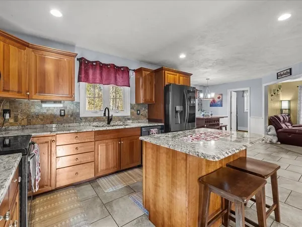 a kitchen with stainless steel appliances granite countertop sink stove refrigerator and cabinets