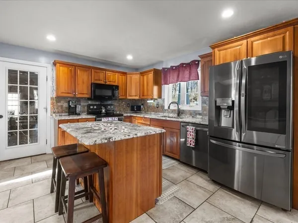 a kitchen with stainless steel appliances granite countertop a refrigerator a stove a sink and a refrigerator