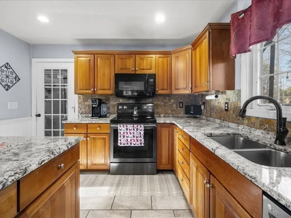 a kitchen with stainless steel appliances granite countertop a sink stove and cabinets