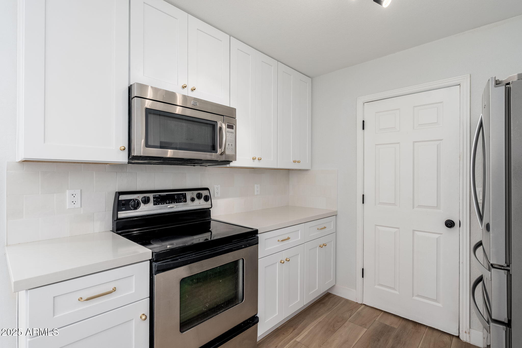 3511 East Baseline Road, Unit 1200 Phoenix, AZ 85042 - Photo 5 of 28 a kitchen with stainless steel appliances white cabinets and a stove top oven
