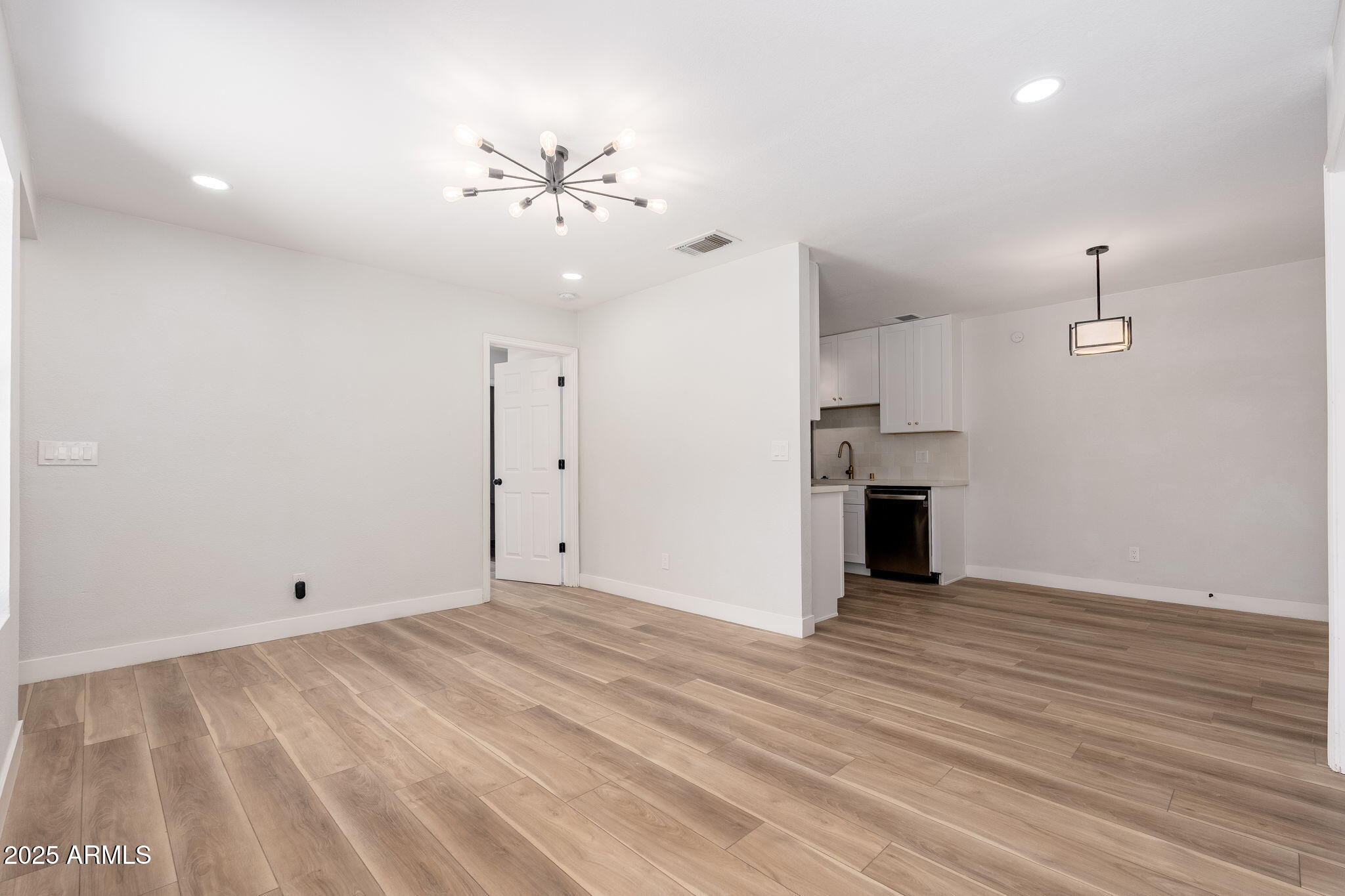 3511 East Baseline Road, Unit 1200 Phoenix, AZ 85042 - Photo 10 of 28 an empty room with chandelier fan and windows
