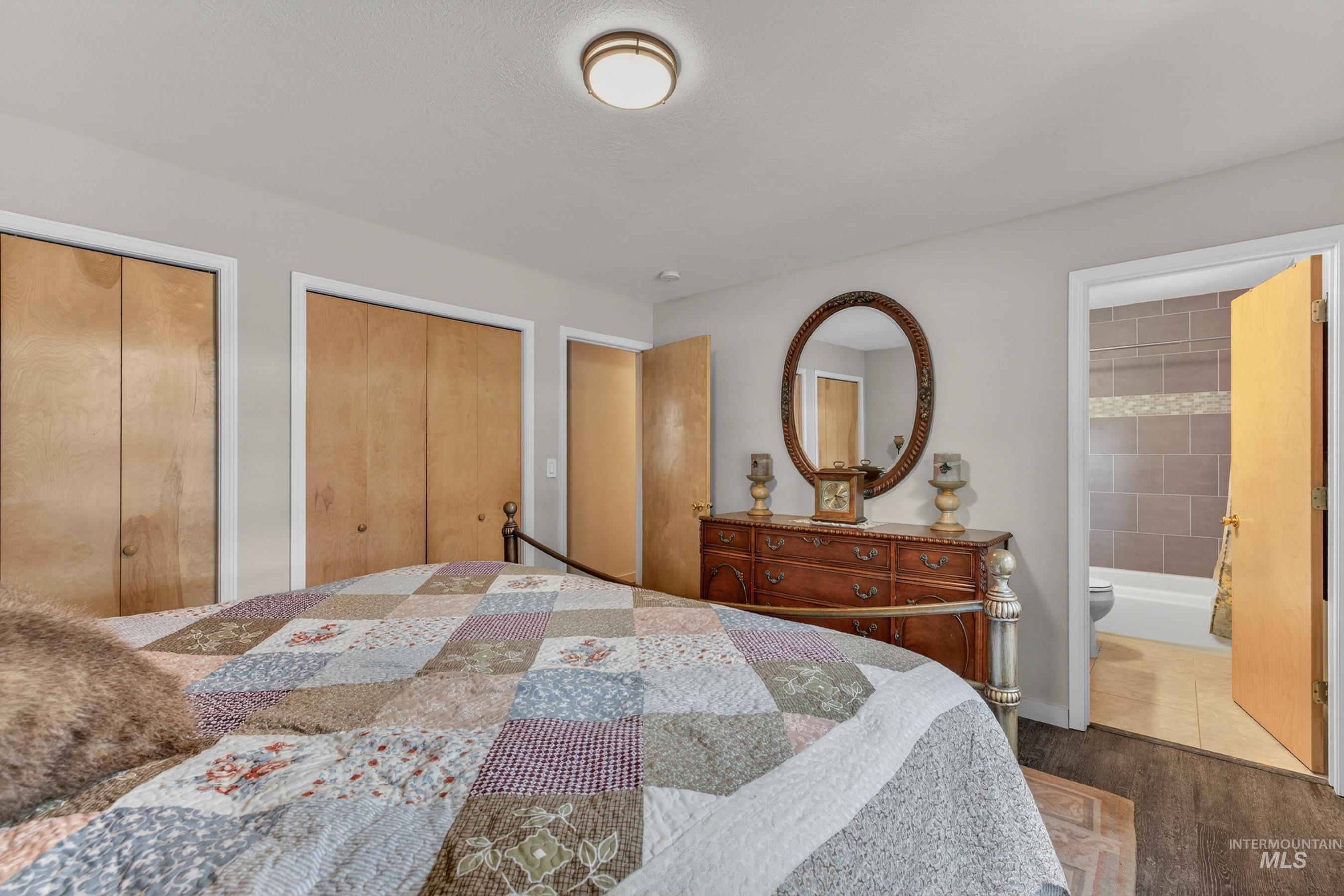 1801 Carico Road McCall, ID 83638 - Photo 14 of 30 Bedroom featuring multiple closets, wood finished floors, and ensuite bath