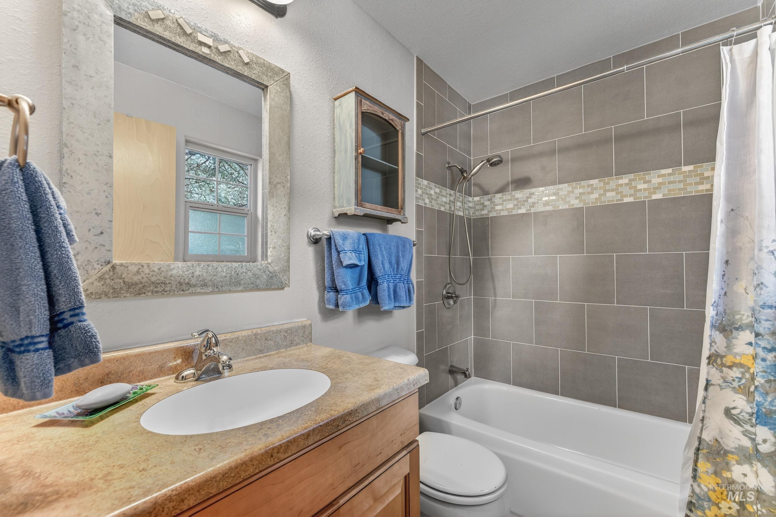 1801 Carico Road McCall, ID 83638 - Photo 15 of 30 Bathroom with vanity, shower / bath combo, and a textured wall