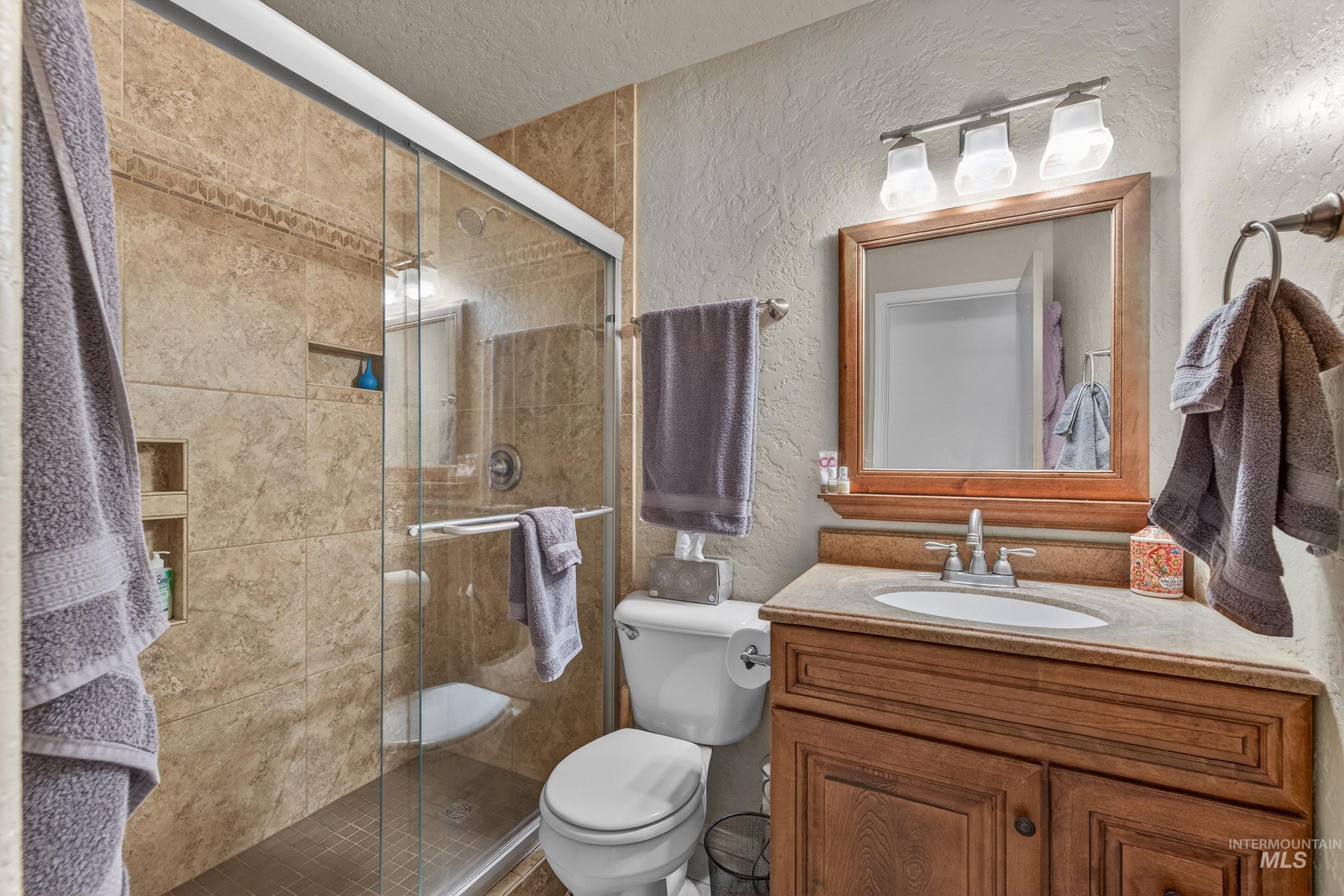 1801 Carico Road McCall, ID 83638 - Photo 19 of 30 Bathroom with a textured wall, vanity, and a stall shower