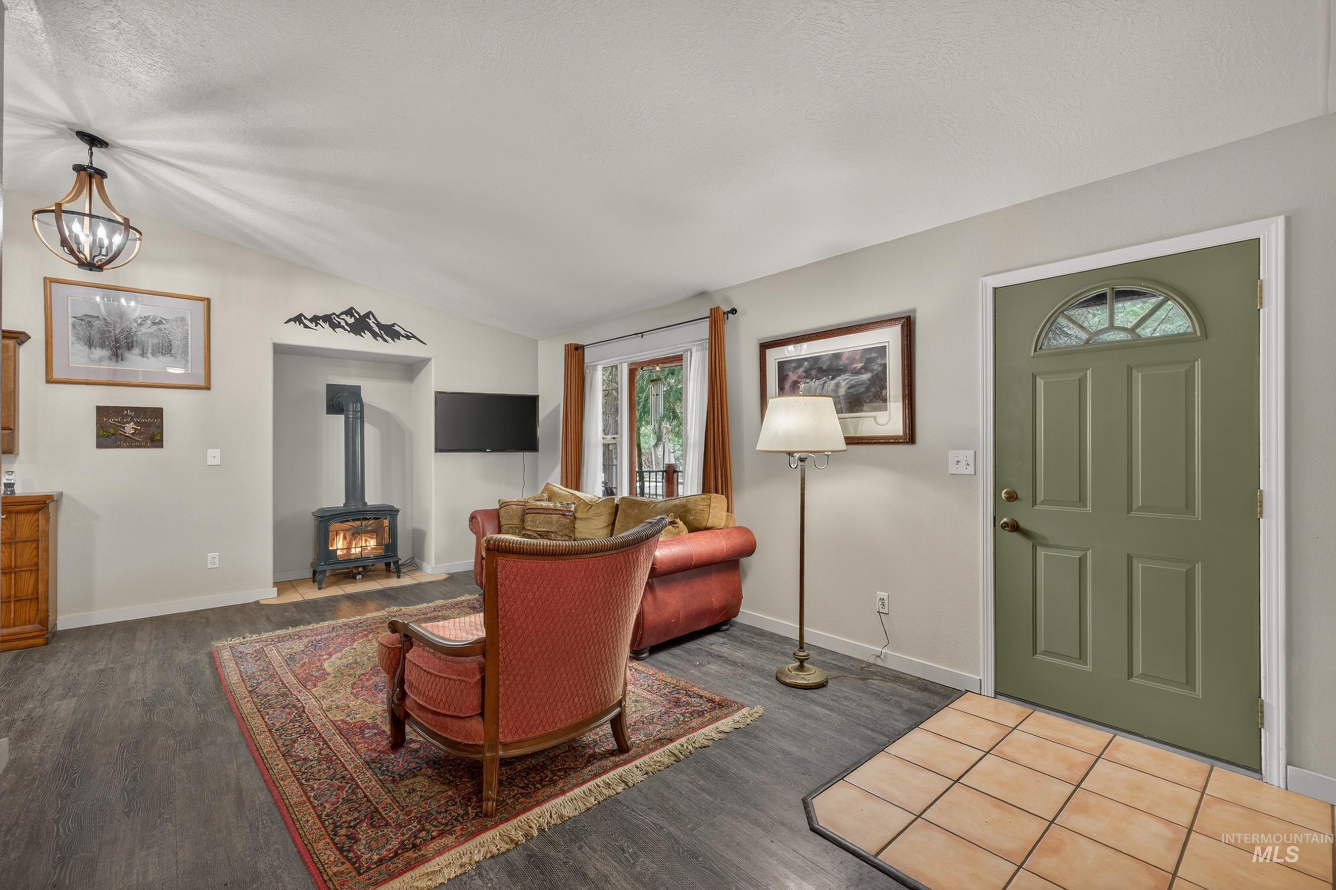 1801 Carico Road McCall, ID 83638 - Photo 5 of 30 Living room with a wood stove, dark wood-style flooring, and vaulted ceiling