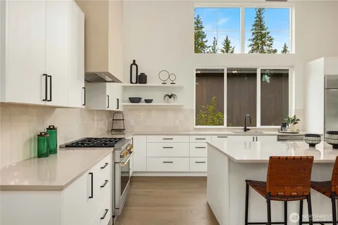 a kitchen with granite countertop a sink stove and cabinets